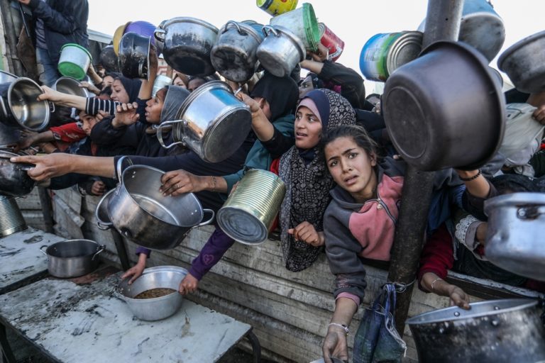People gather to receive meals from the Rafah charitable kitchen (Tekka) as Palestinians face famine, in Khan Yunis, in the southern Gaza Strip, on January 2, 2025.